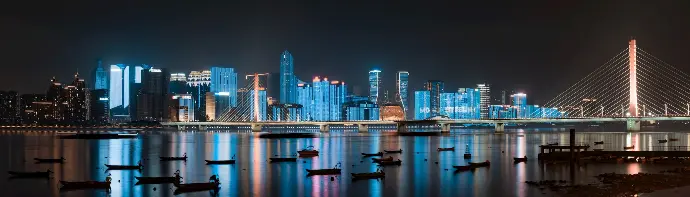 city skyline across body of water during night time