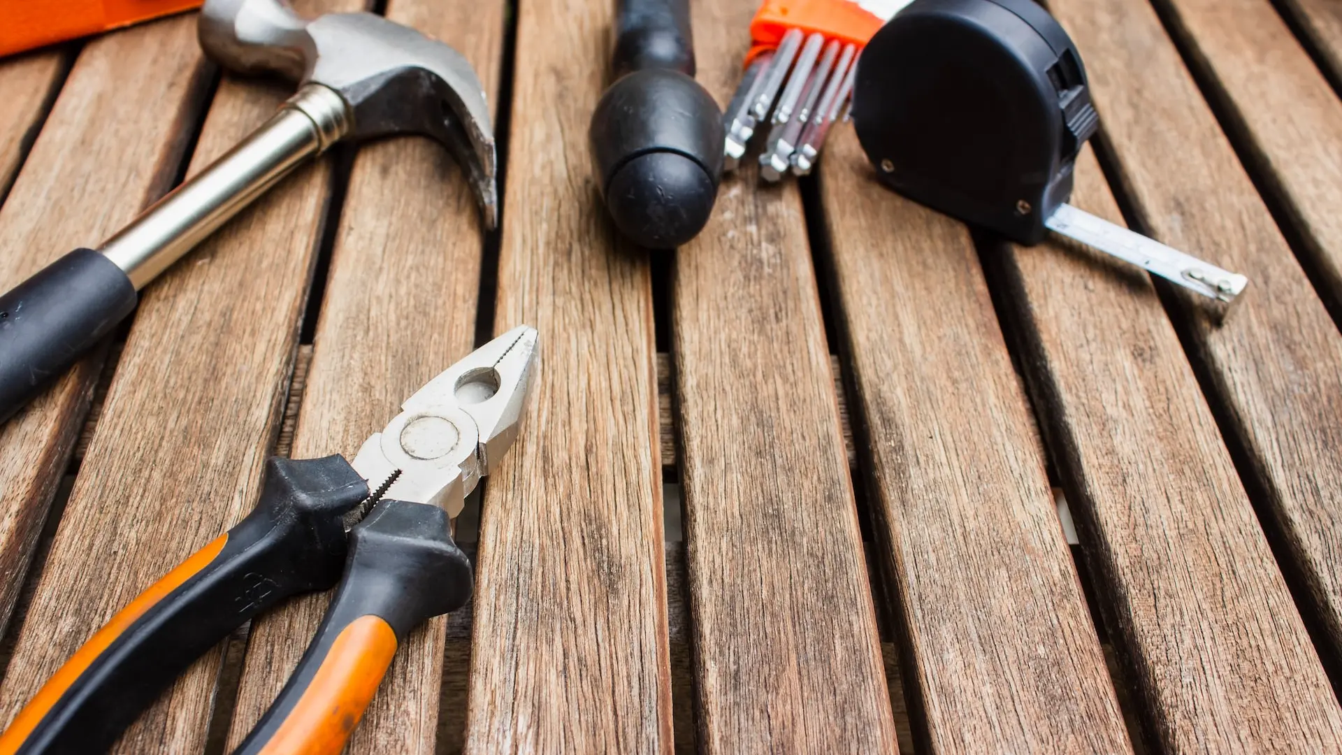 assorted-type carpentry tools on brown surface