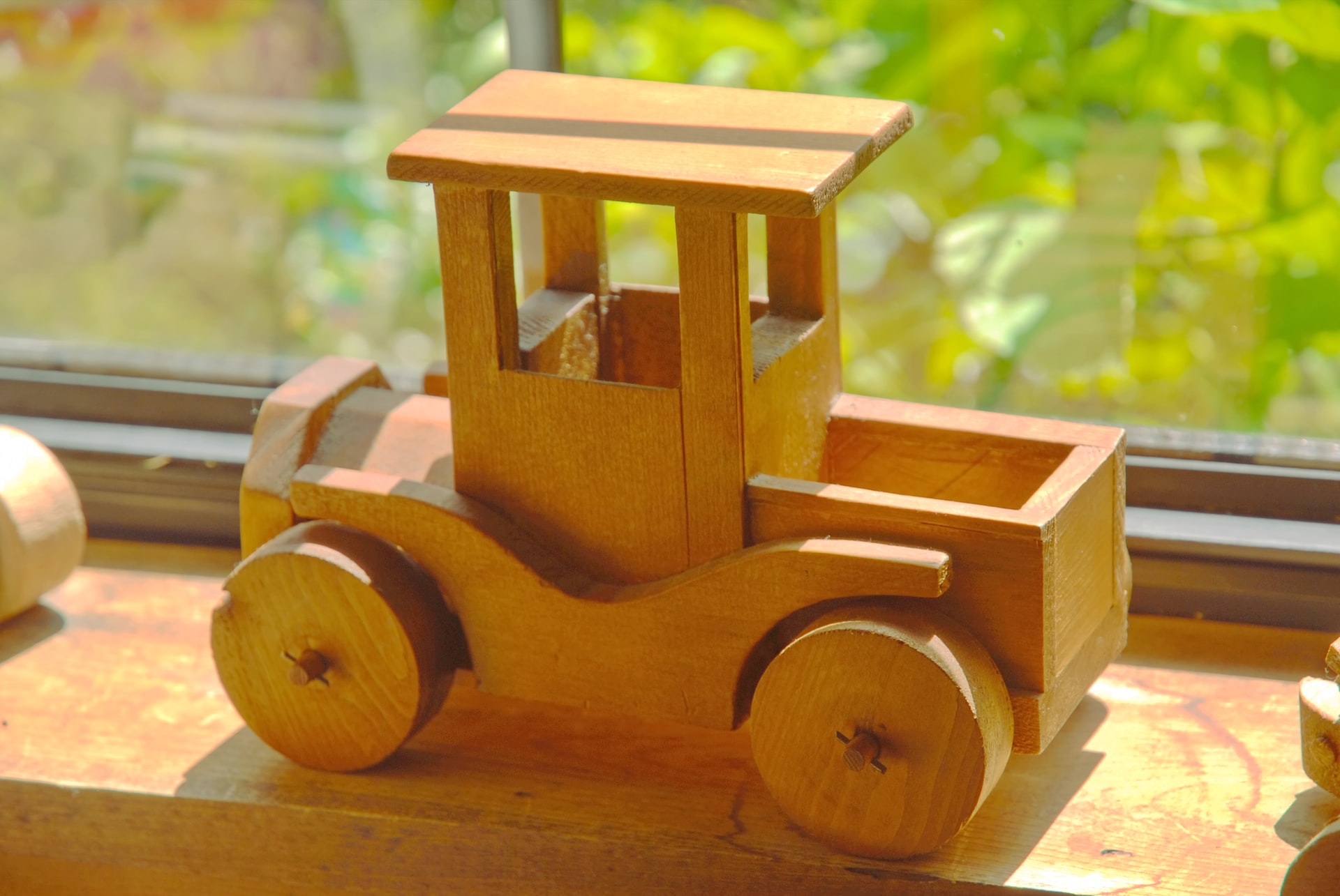 a wooden toy truck sitting on top of a window sill